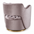 A modern barrel-style accent chair upholstered in rayon Amethyst velvet, featuring a tufted seat, a wraparound tufted backrest, and a round gold finished wood  base